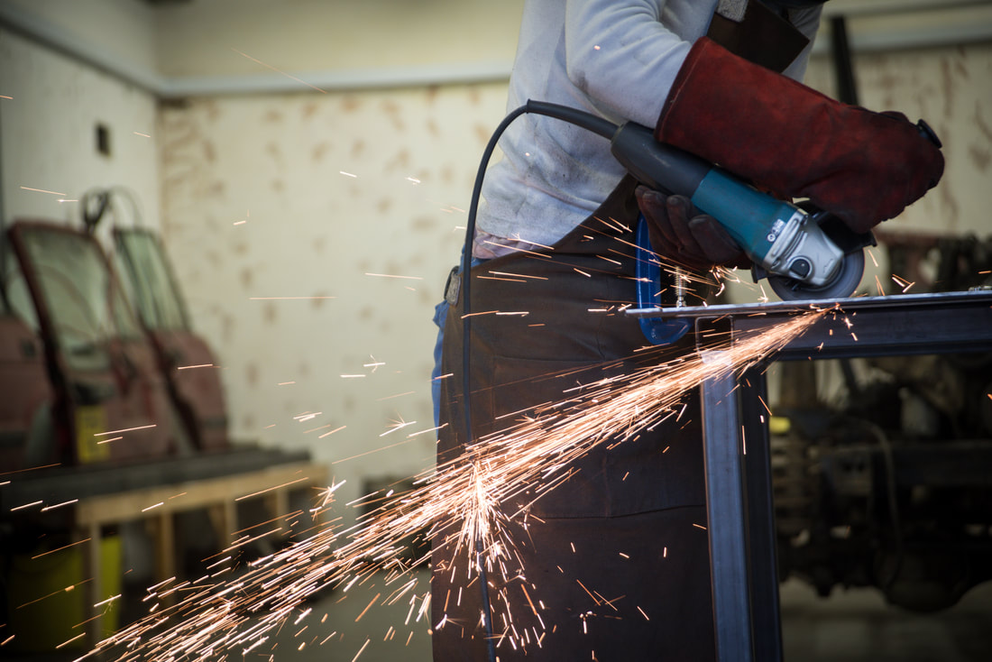 sparks fly from an angle grinder as it cuts through metal